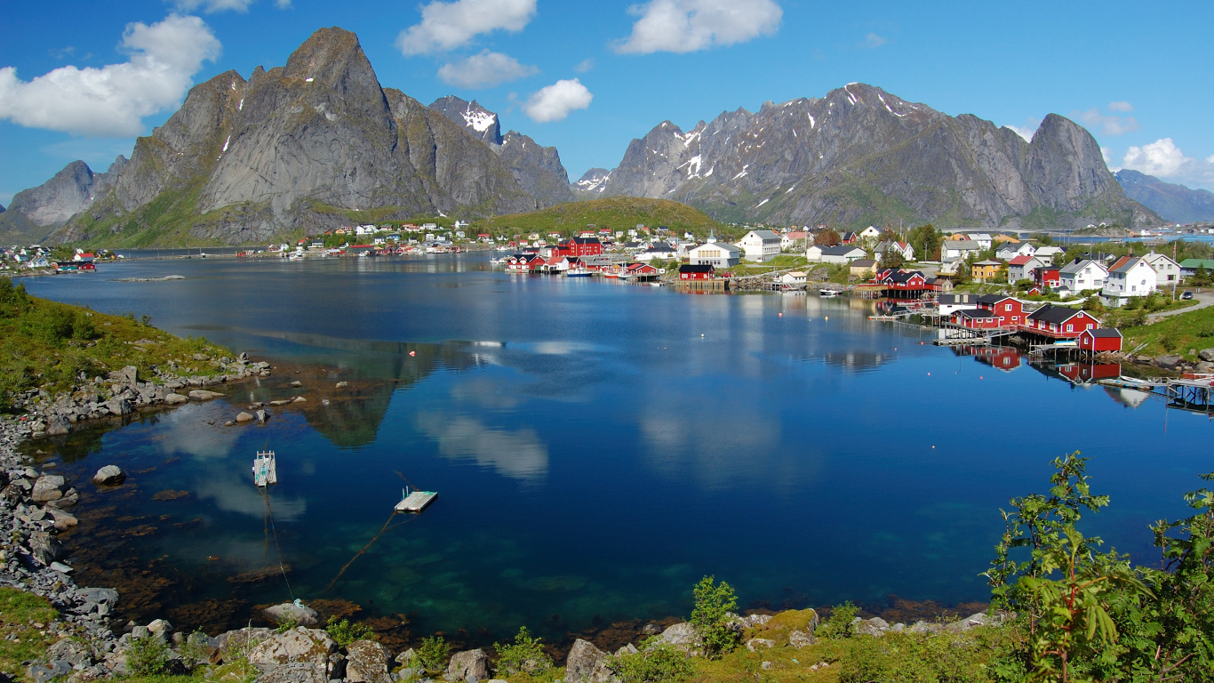 Houses Near Lake and Mountain Range Under Blue Sky During Daytime. Wallpaper in 1366x768 Resolution