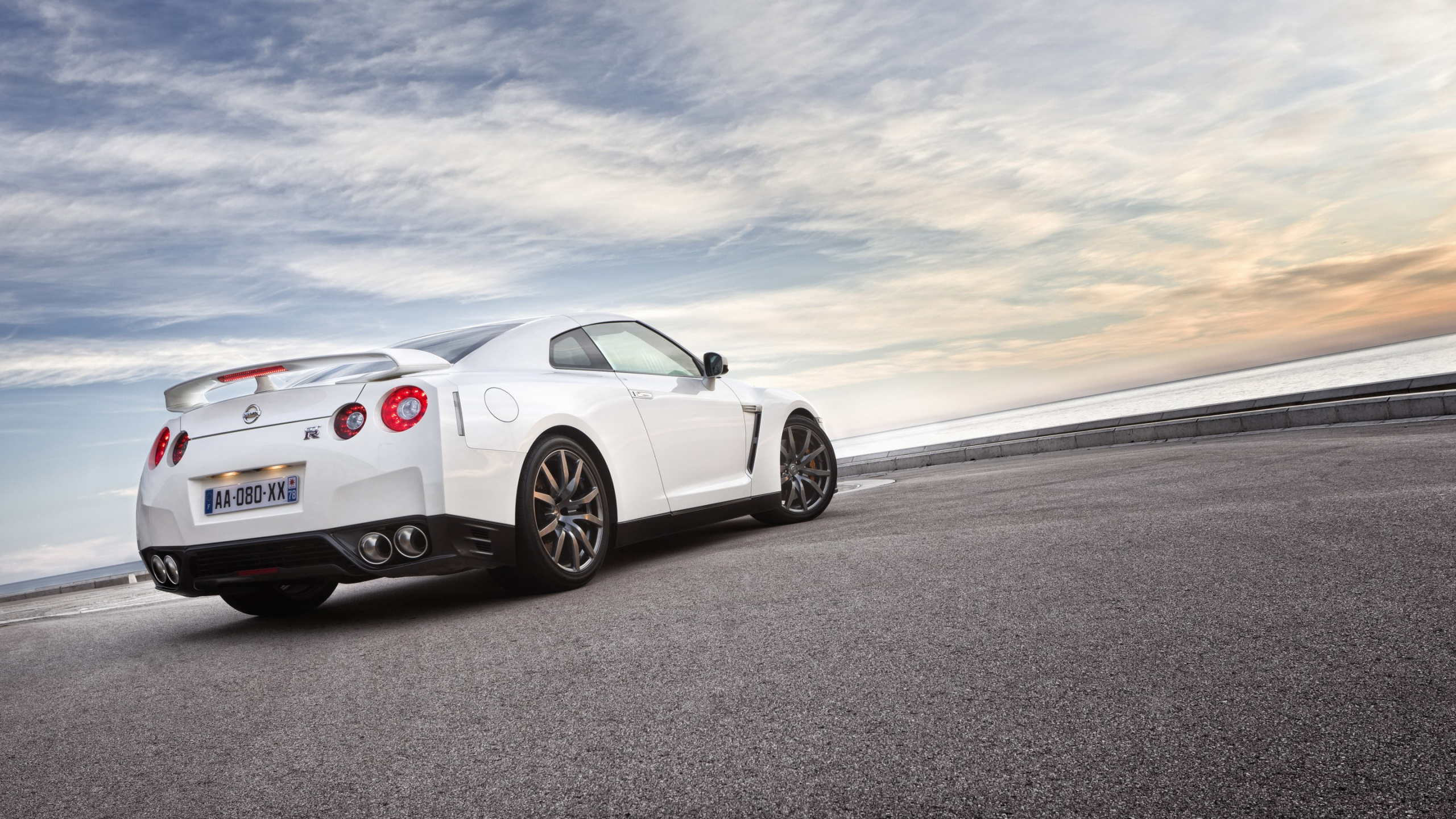 Porsche 911 Blanco en la Carretera Bajo un Cielo Nublado. Wallpaper in 2560x1440 Resolution