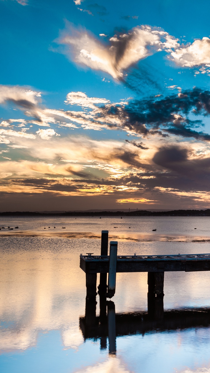 Brown Wooden Dock on Calm Water Under Blue and White Cloudy Sky During Daytime. Wallpaper in 720x1280 Resolution