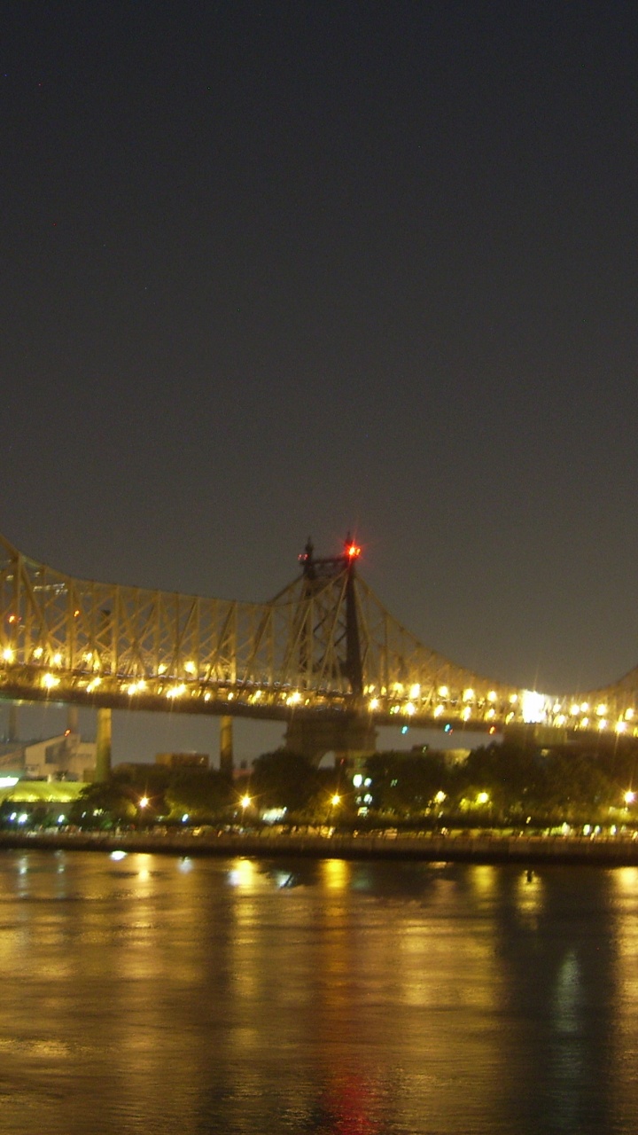 Lighted Bridge Over Water During Night Time. Wallpaper in 720x1280 Resolution