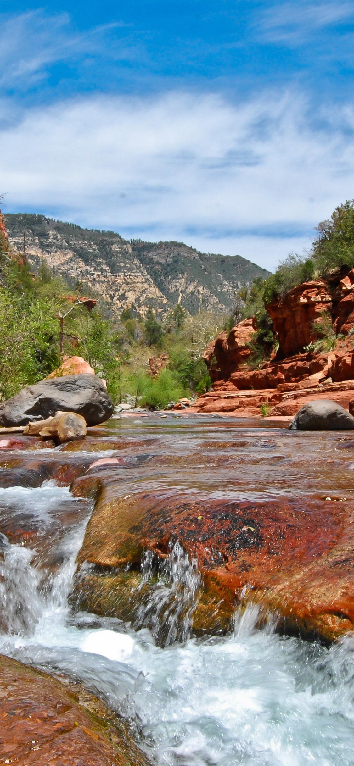 River in Between Brown and Green Mountains Under Blue Sky During Daytime. Wallpaper in 1125x2436 Resolution