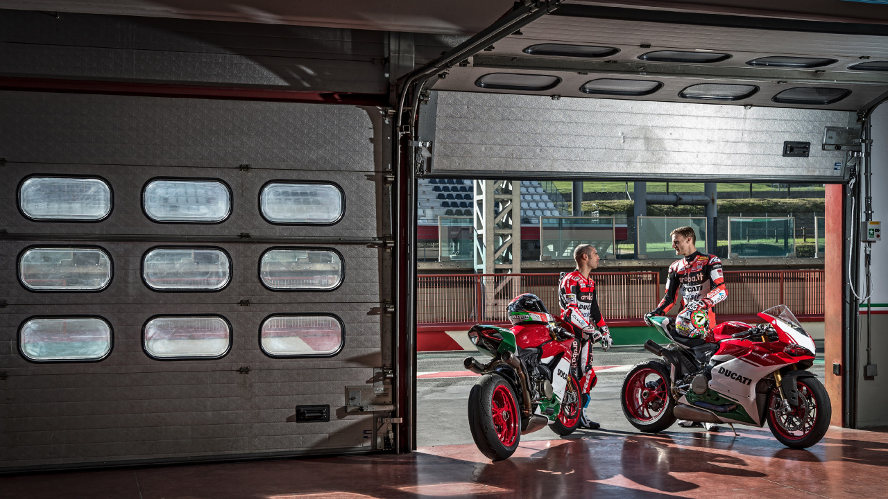 Man in Red and Black Motorcycle Suit Riding on Red Motorcycle. Wallpaper in 1280x720 Resolution