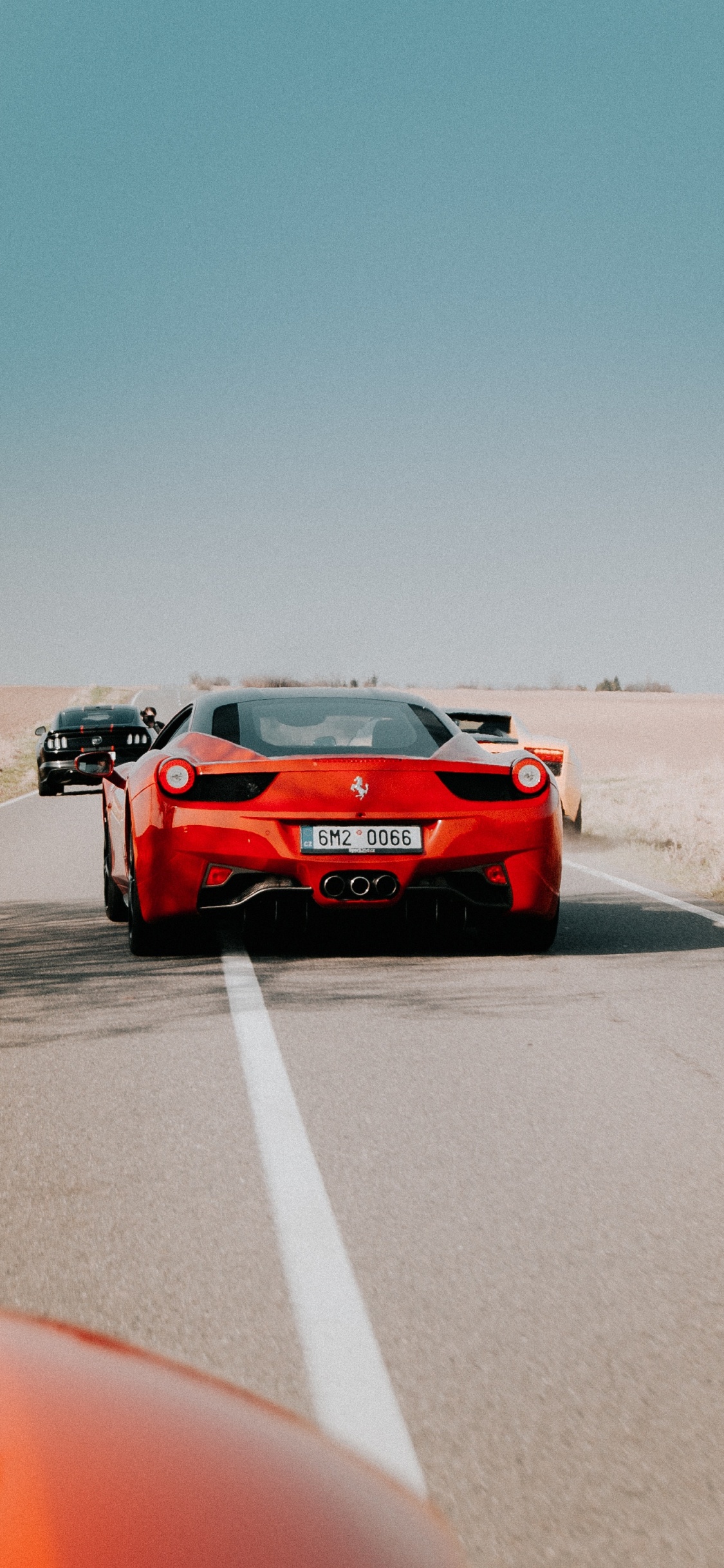 Roter Porsche 911 Auf Grauer Asphaltstraße Tagsüber. Wallpaper in 1125x2436 Resolution