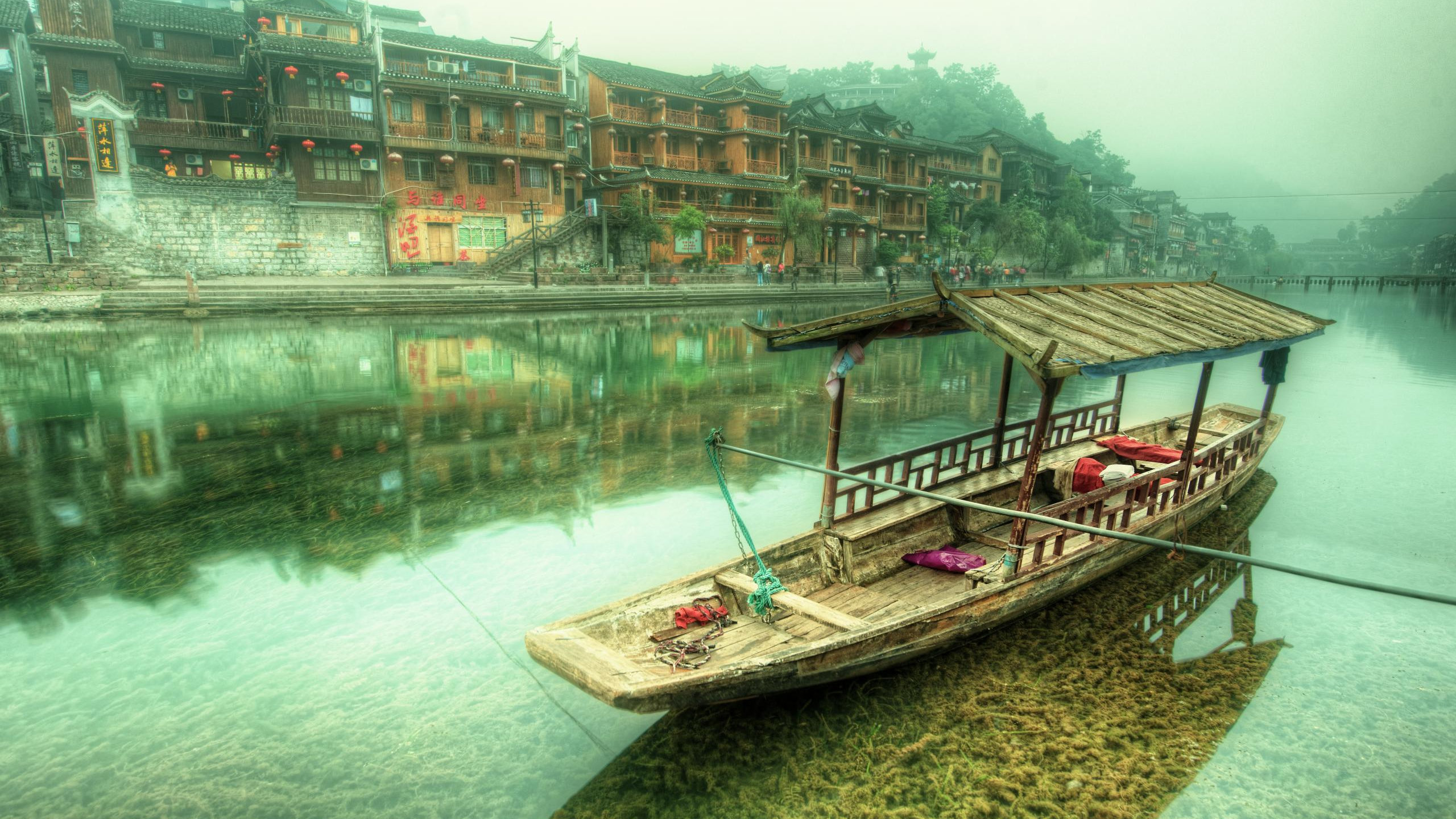 Brown Wooden Boat on River Near Brown Concrete Building During Daytime. Wallpaper in 2560x1440 Resolution