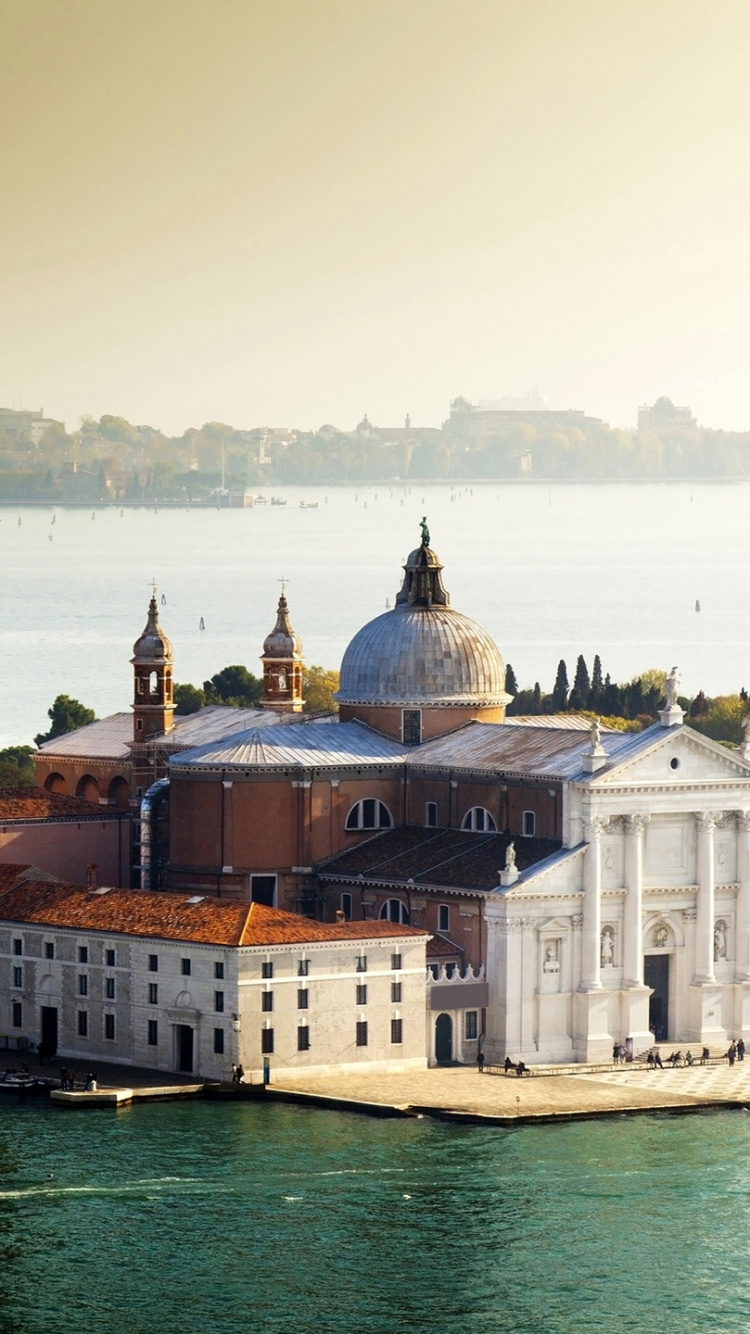 Brown and White Concrete Building Near Body of Water During Daytime. Wallpaper in 750x1334 Resolution