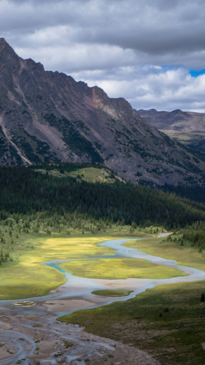 Grüne Wiese in Der Nähe Des Berges Unter Bewölktem Himmel Tagsüber Sky. Wallpaper in 720x1280 Resolution