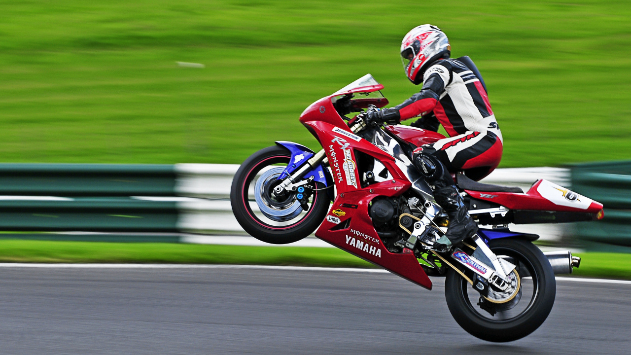 Man in Red and Black Motorcycle Suit Riding on Red Sports Bike. Wallpaper in 1280x720 Resolution