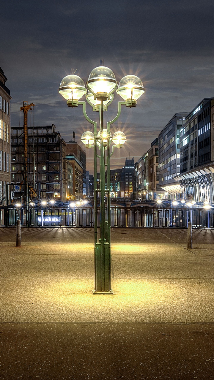 Lampadaires Éclairés au Milieu de la Ville Pendant la Nuit. Wallpaper in 720x1280 Resolution