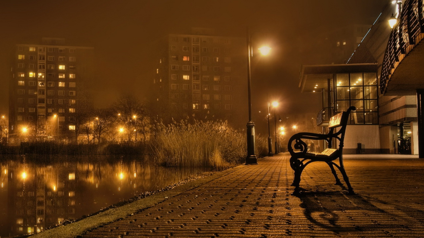 Bench on Sidewalk Near Body of Water During Sunset. Wallpaper in 1366x768 Resolution
