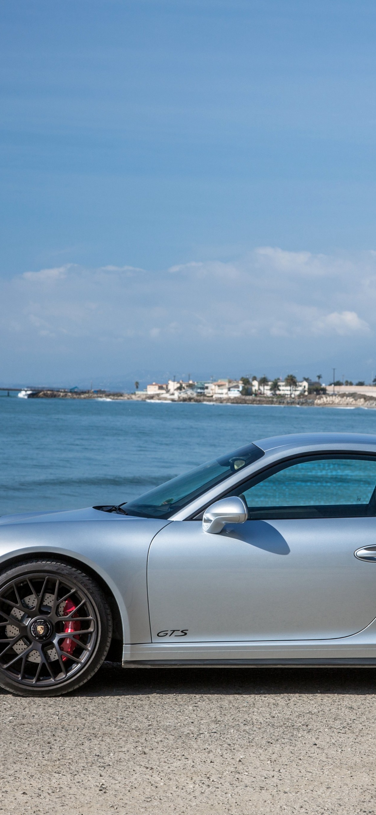 Silver Porsche 911 Estacionado en la Orilla Del Mar Durante el Día. Wallpaper in 1242x2688 Resolution