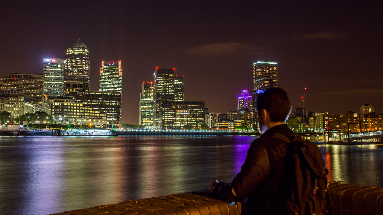 Man in Black Jacket Sitting on Brown Wooden Dock During Night Time. Wallpaper in 1280x720 Resolution