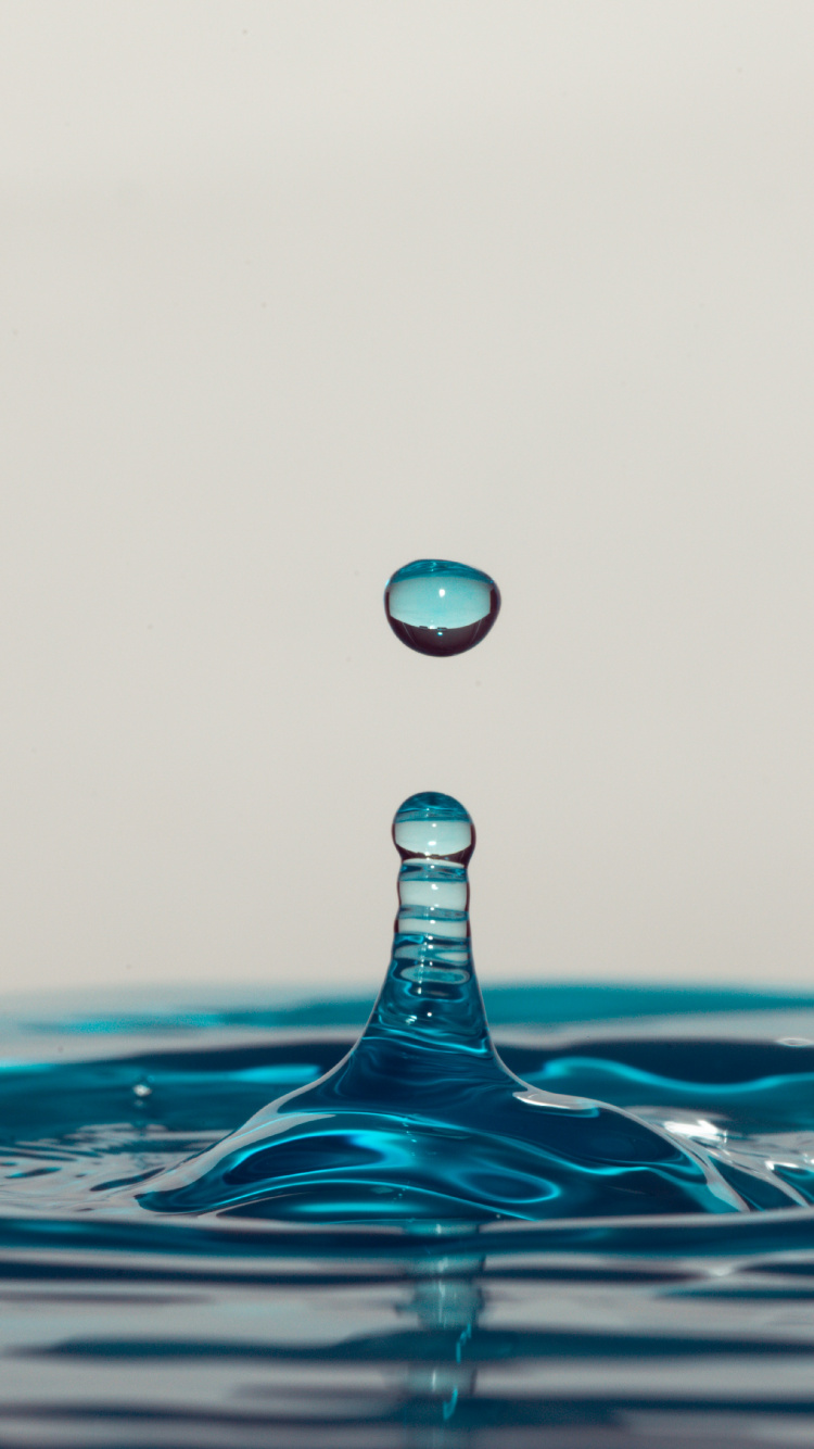 Wassertropfen Auf Blauem Wasser. Wallpaper in 750x1334 Resolution