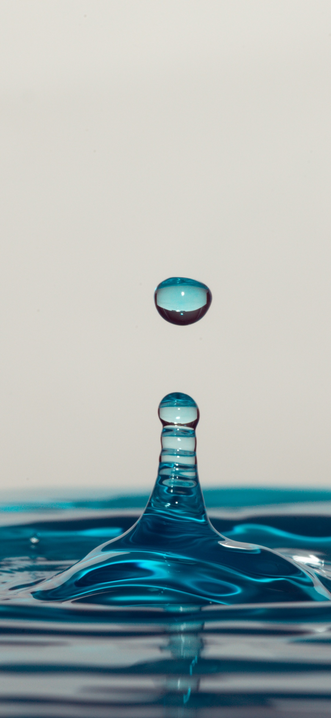 Water Drop on Blue Water. Wallpaper in 1125x2436 Resolution
