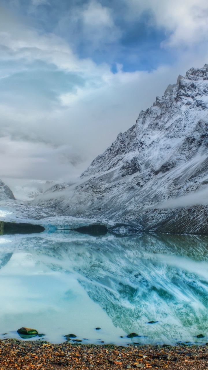 Snow Covered Mountain Near Body of Water Under Cloudy Sky During Daytime. Wallpaper in 720x1280 Resolution