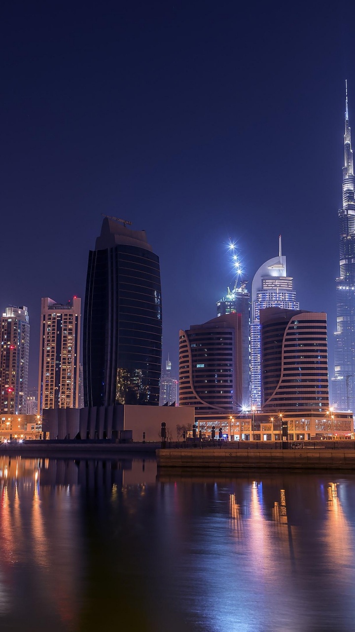 City Skyline Across Body of Water During Night Time. Wallpaper in 720x1280 Resolution