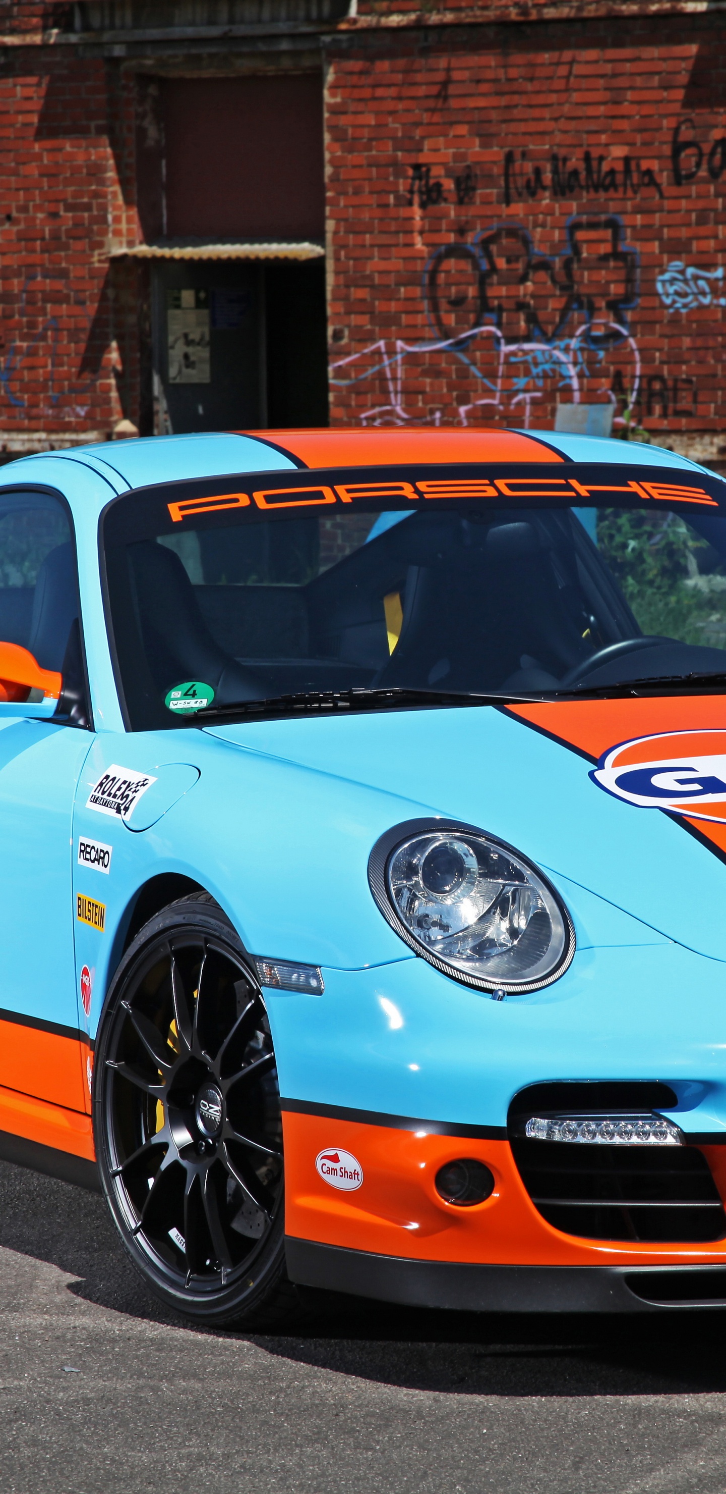 Porsche 911 Azul y Blanco Estacionado Cerca Del Edificio de Ladrillo Marrón Durante el Día. Wallpaper in 1440x2960 Resolution