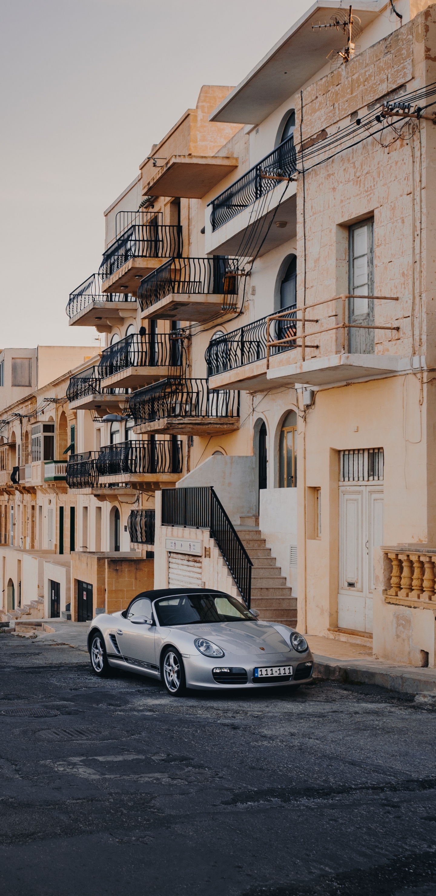 Porsche 911 Blanco Estacionado Junto al Edificio de Hormigón Amarillo Durante el Día. Wallpaper in 1440x2960 Resolution