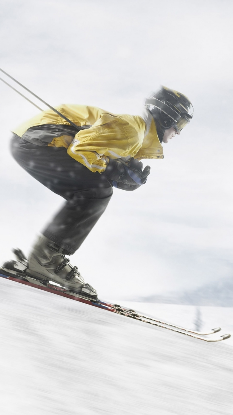 Mann in Gelber Jacke Und Blauer Denim-Jeans Reitet Skischaufeln Auf Schneebedecktem Boden Während. Wallpaper in 750x1334 Resolution