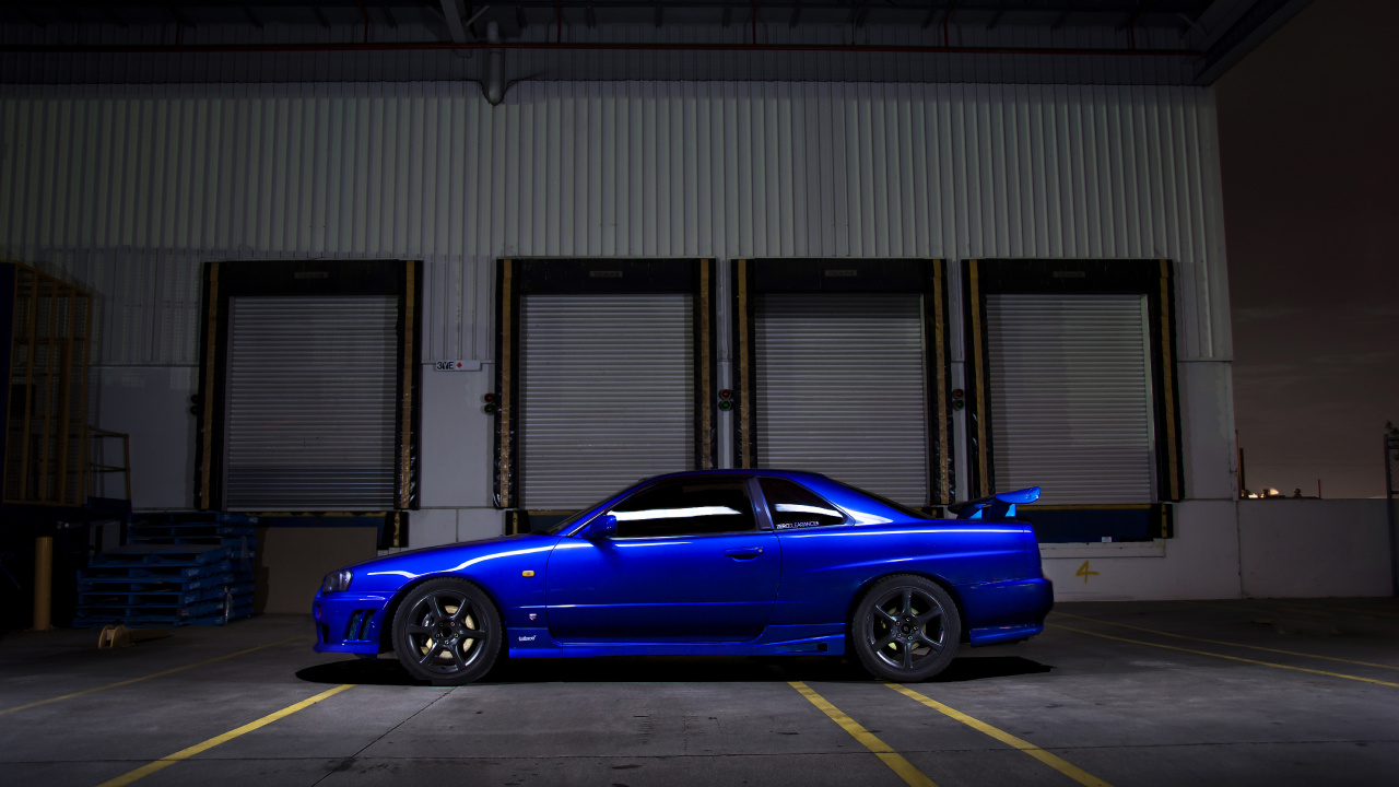 Sedán Azul Estacionado Frente al Edificio. Wallpaper in 1280x720 Resolution