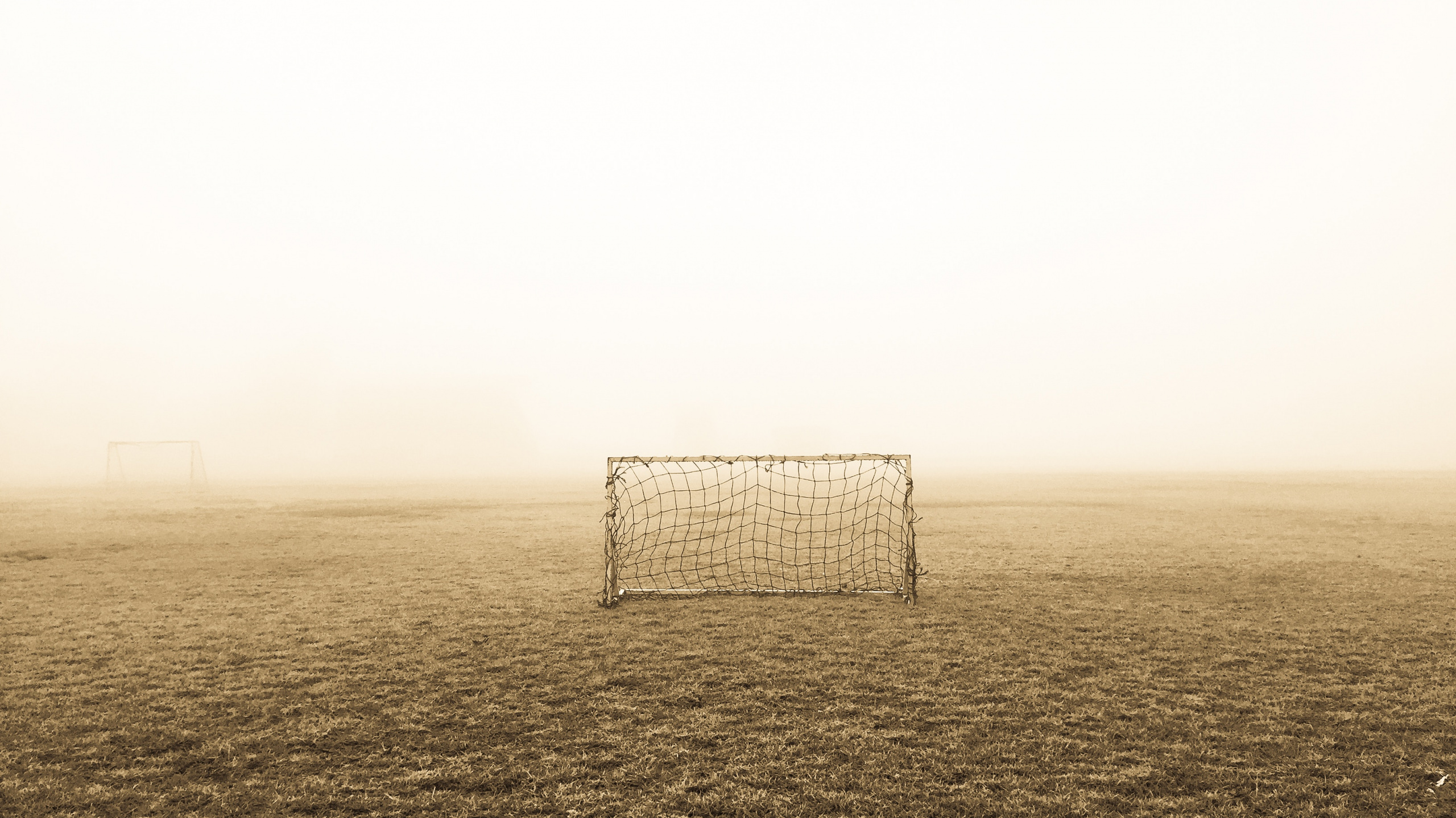 White and Black Soccer Goal on Field Covered With Fog. Wallpaper in 2560x1440 Resolution