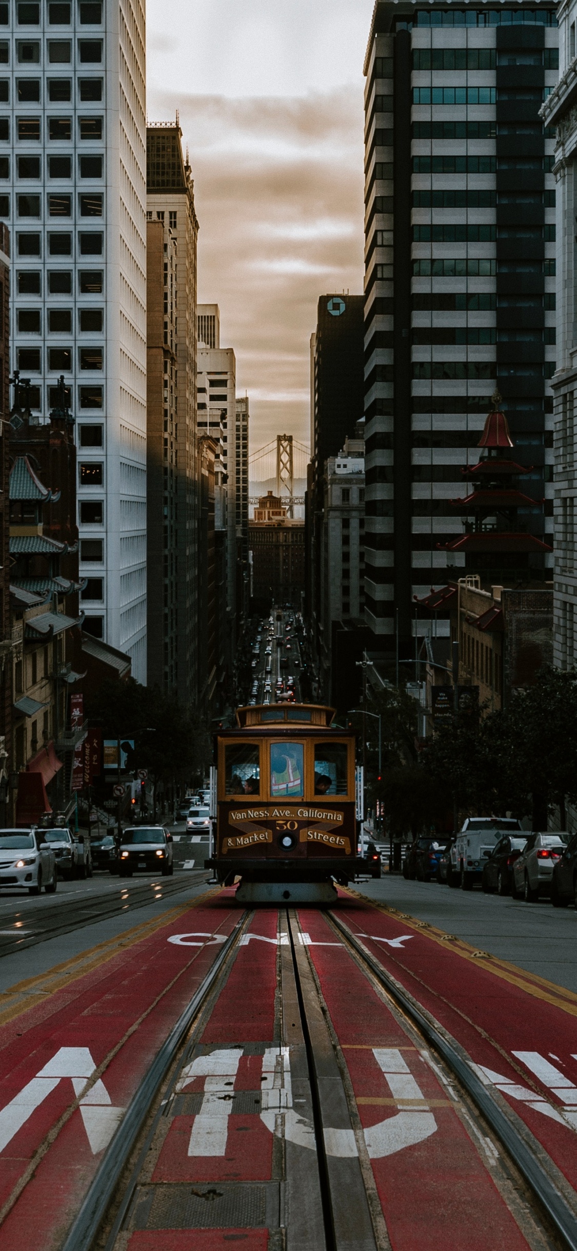 Voitures Sur Route Entre Les Immeubles de Grande Hauteur Pendant la Journée. Wallpaper in 1125x2436 Resolution