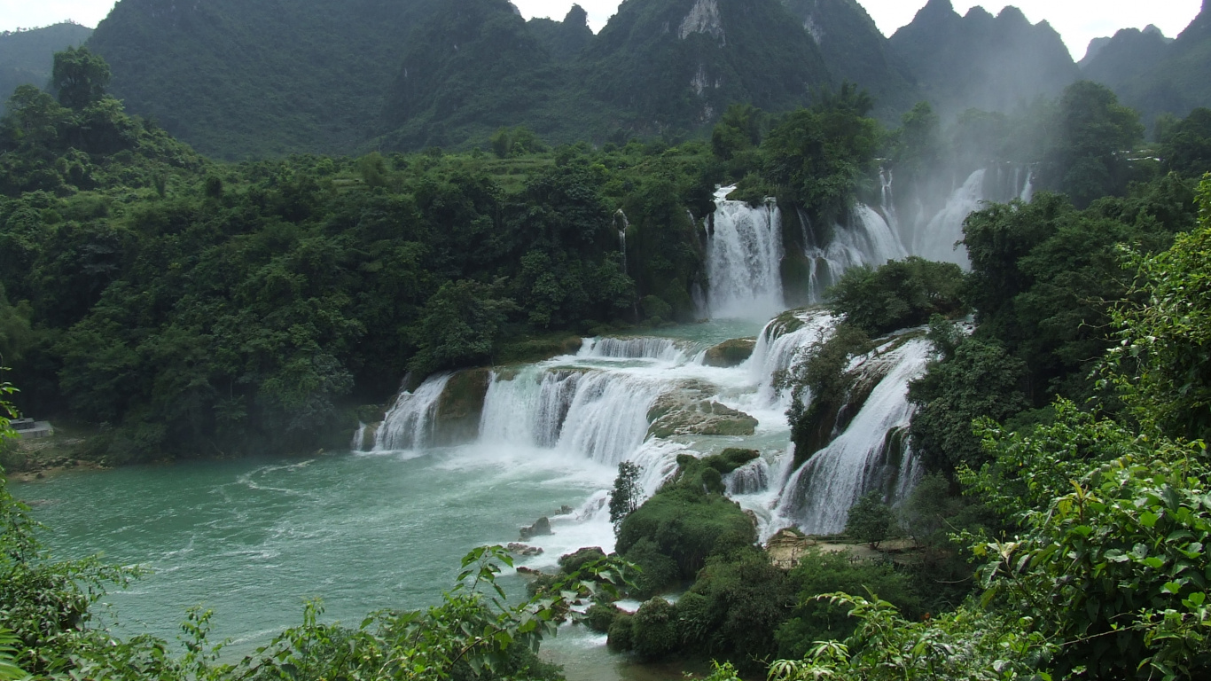 Waterfalls Near Green Trees and Mountain During Daytime. Wallpaper in 1366x768 Resolution