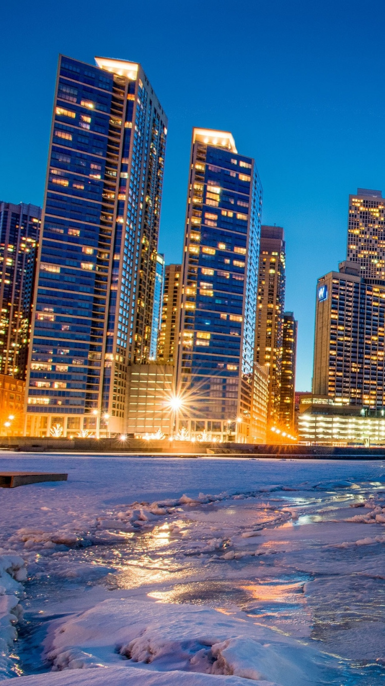 Horizonte de la Ciudad a Través Del Cuerpo de Agua Durante la Noche.. Wallpaper in 750x1334 Resolution