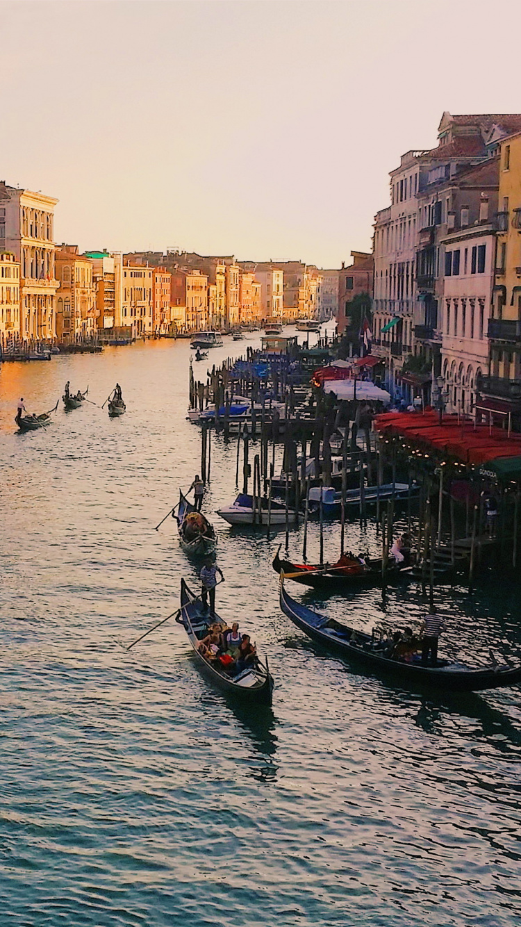 Leute, Die Tagsüber Auf Dem Boot Auf Dem Fluss in Der Nähe Von Gebäuden Fahren. Wallpaper in 750x1334 Resolution