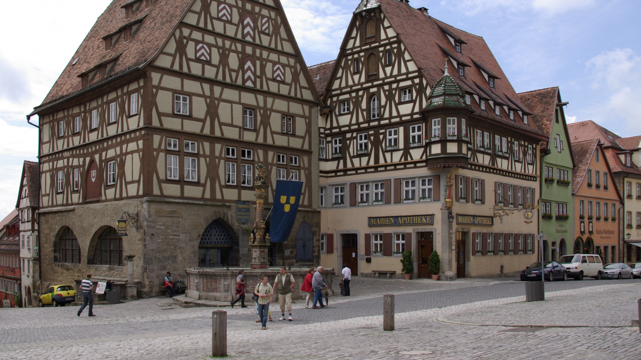 Personnes Marchant Dans la Rue Près D'un Bâtiment en Béton Brun Pendant la Journée. Wallpaper in 1280x720 Resolution