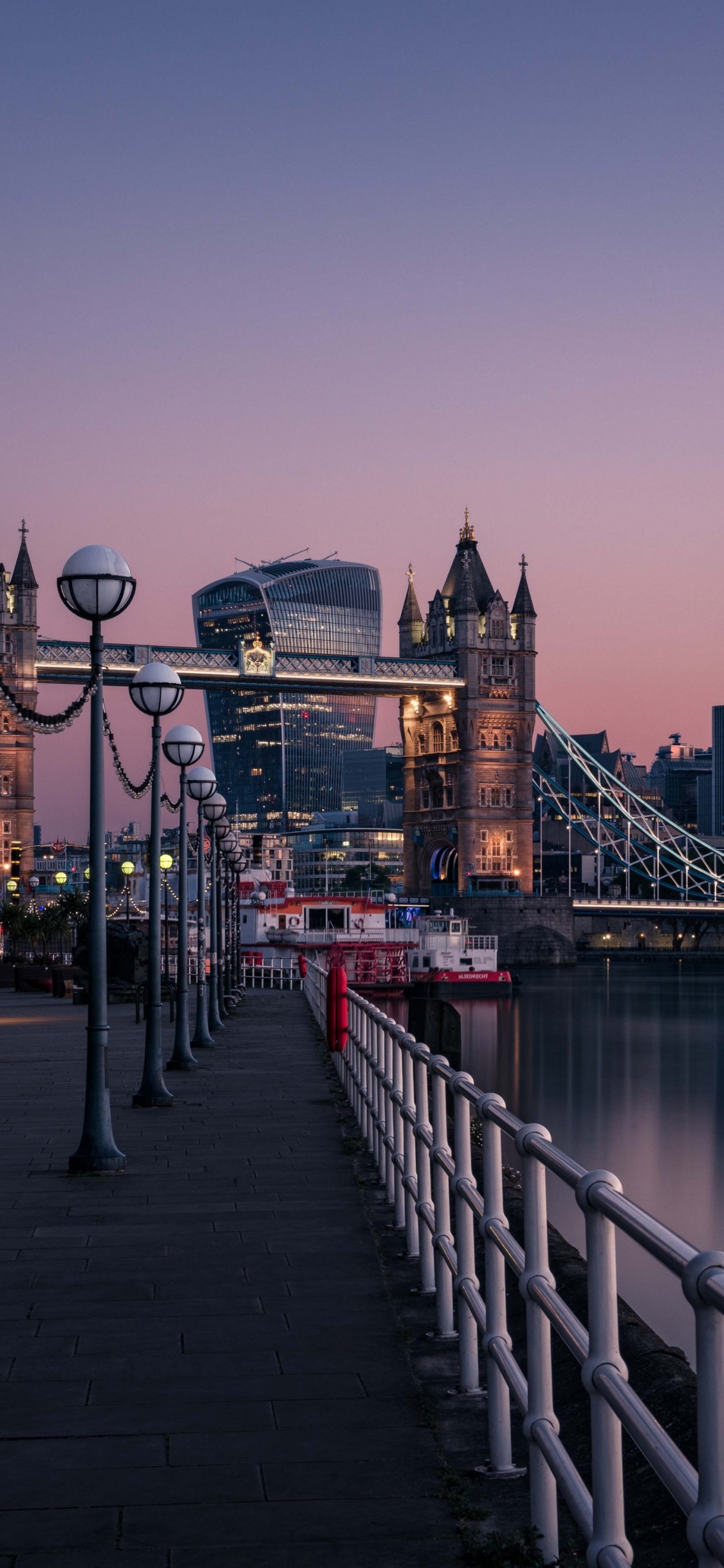 Bridge Over River Near City Buildings During Daytime. Wallpaper in 1125x2436 Resolution