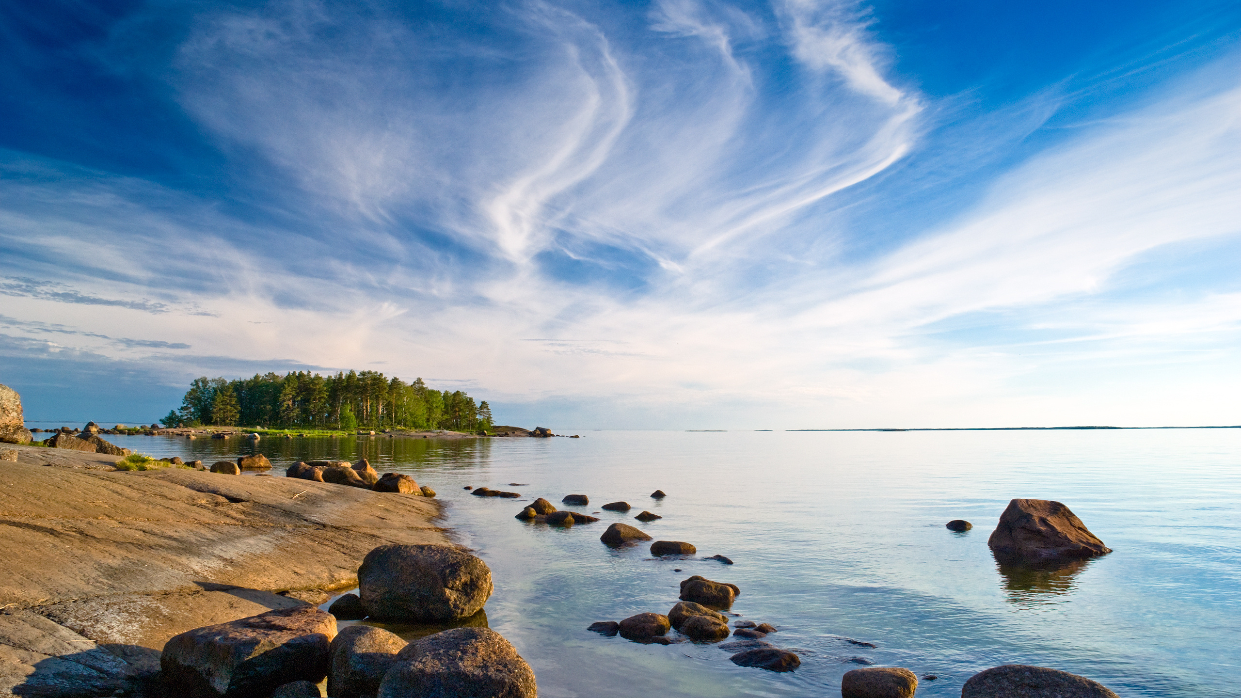 Brown Rocks on Body of Water Under Blue Sky During Daytime. Wallpaper in 2560x1440 Resolution