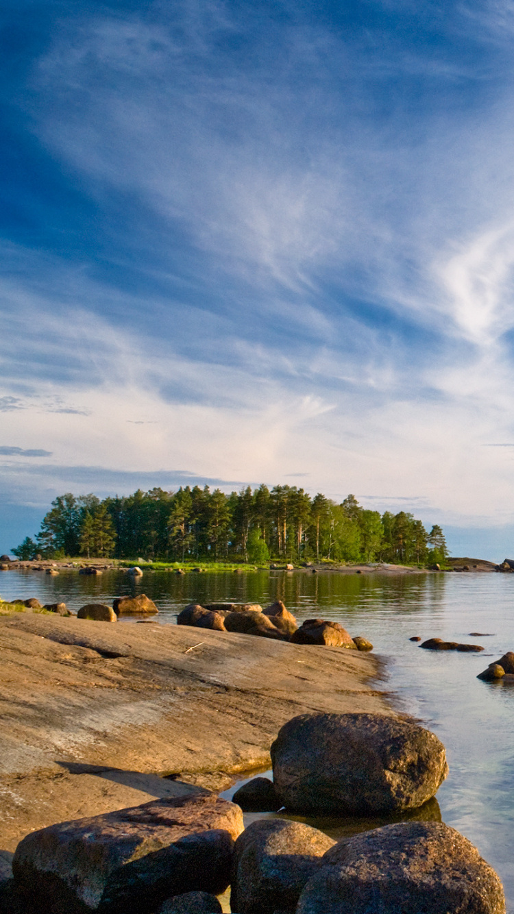 Brown Rocks on Body of Water Under Blue Sky During Daytime. Wallpaper in 750x1334 Resolution