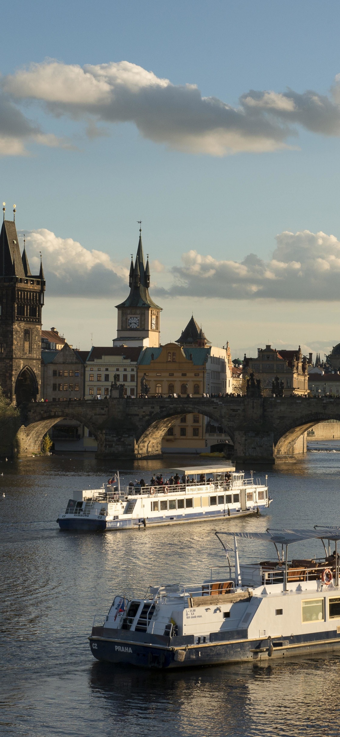 Bateau Blanc Sur L'eau Près D'un Bâtiment en Béton Brun Pendant la Journée. Wallpaper in 1125x2436 Resolution