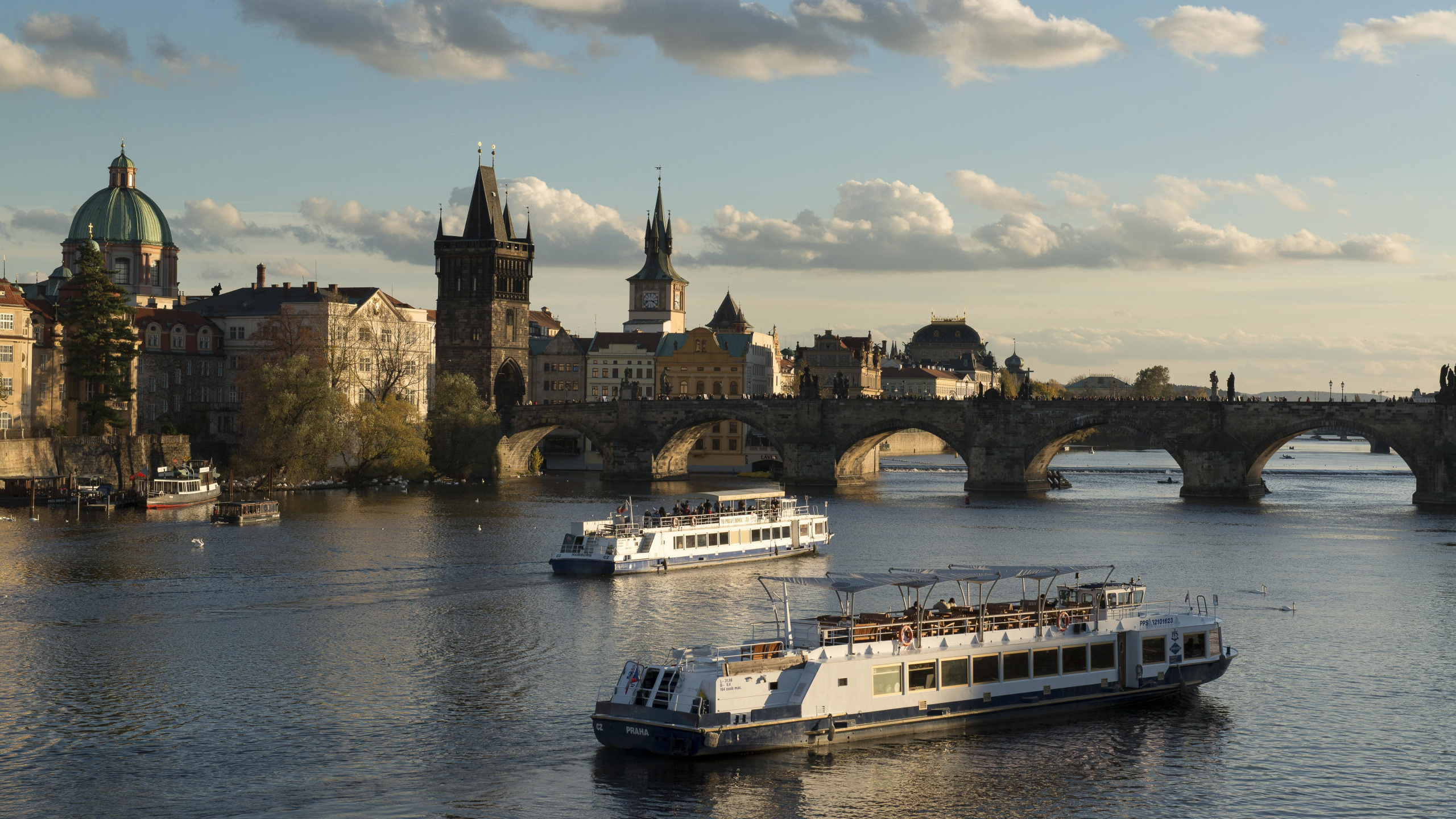 Barco Blanco Sobre el Agua Cerca Del Edificio de Hormigón Marrón Durante el Día. Wallpaper in 2560x1440 Resolution