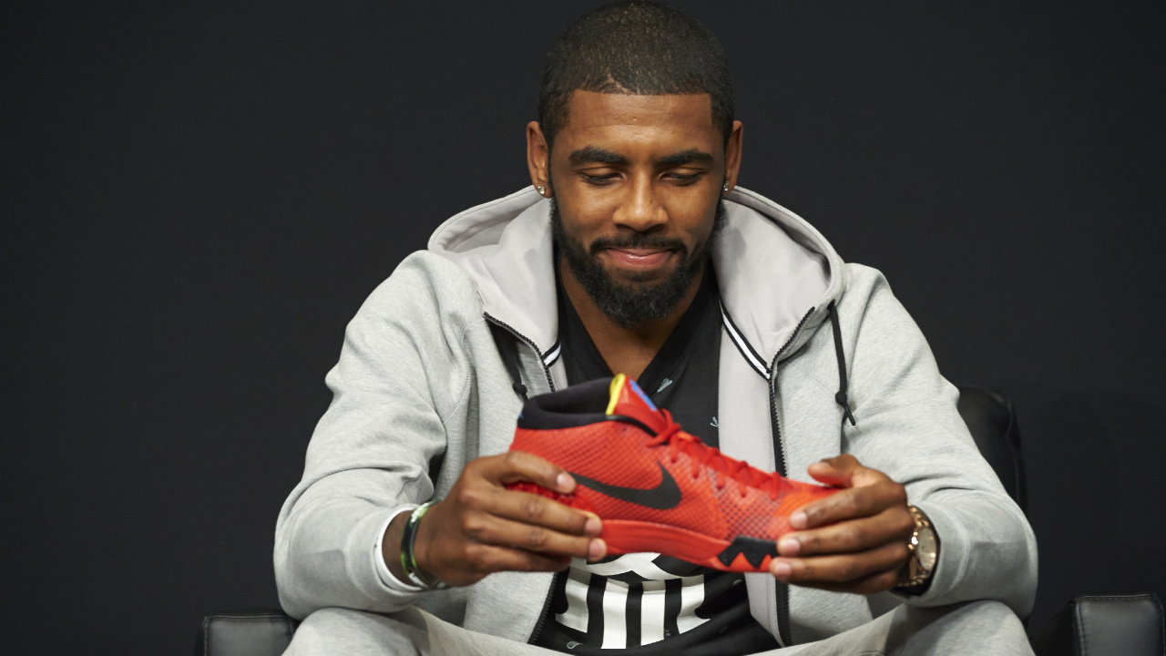 Homme en Chemise Grise Tenant Une Chaussure de Sport Nike Orange. Wallpaper in 1280x720 Resolution