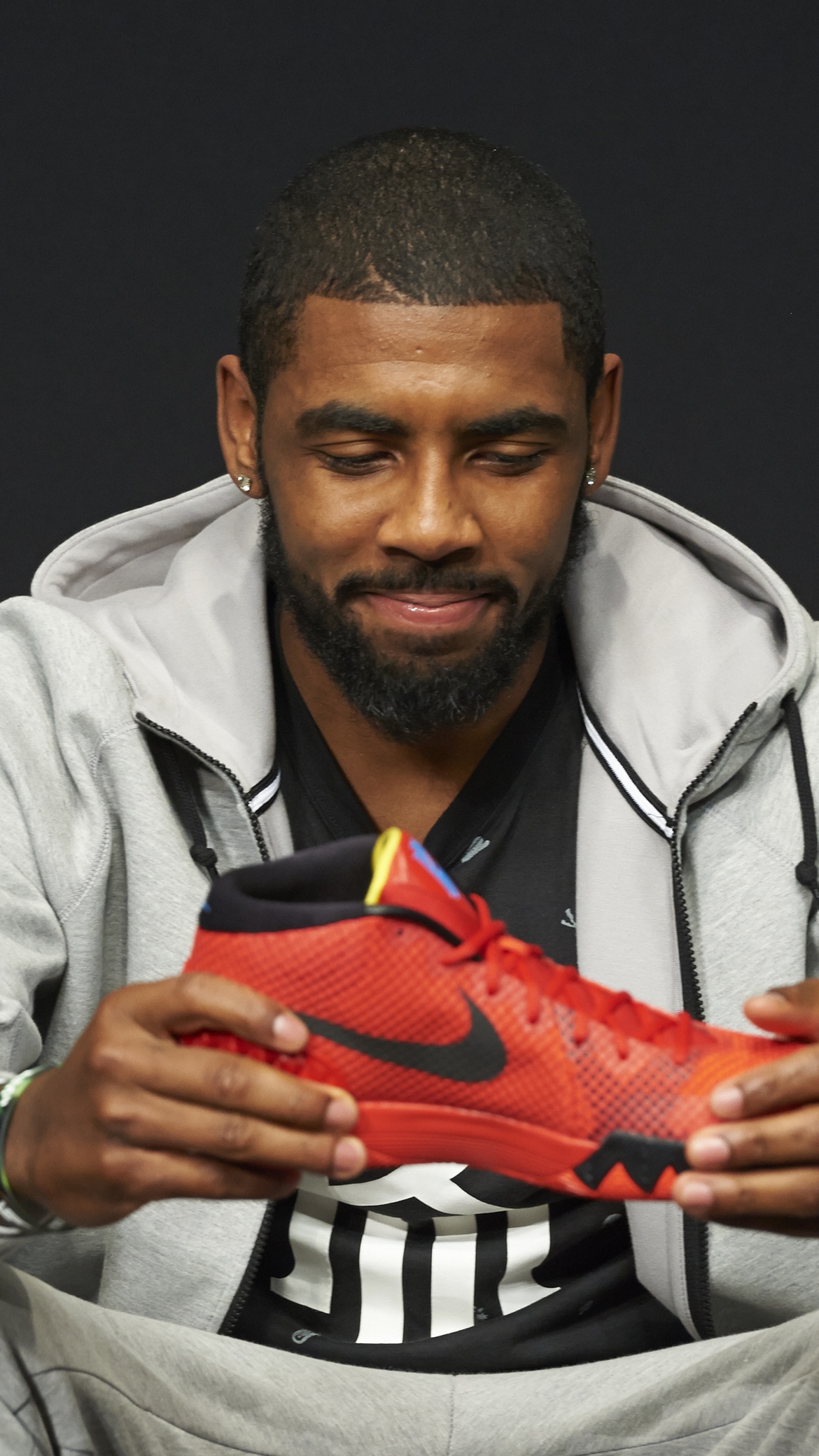 Homme en Chemise Grise Tenant Une Chaussure de Sport Nike Orange. Wallpaper in 1440x2560 Resolution