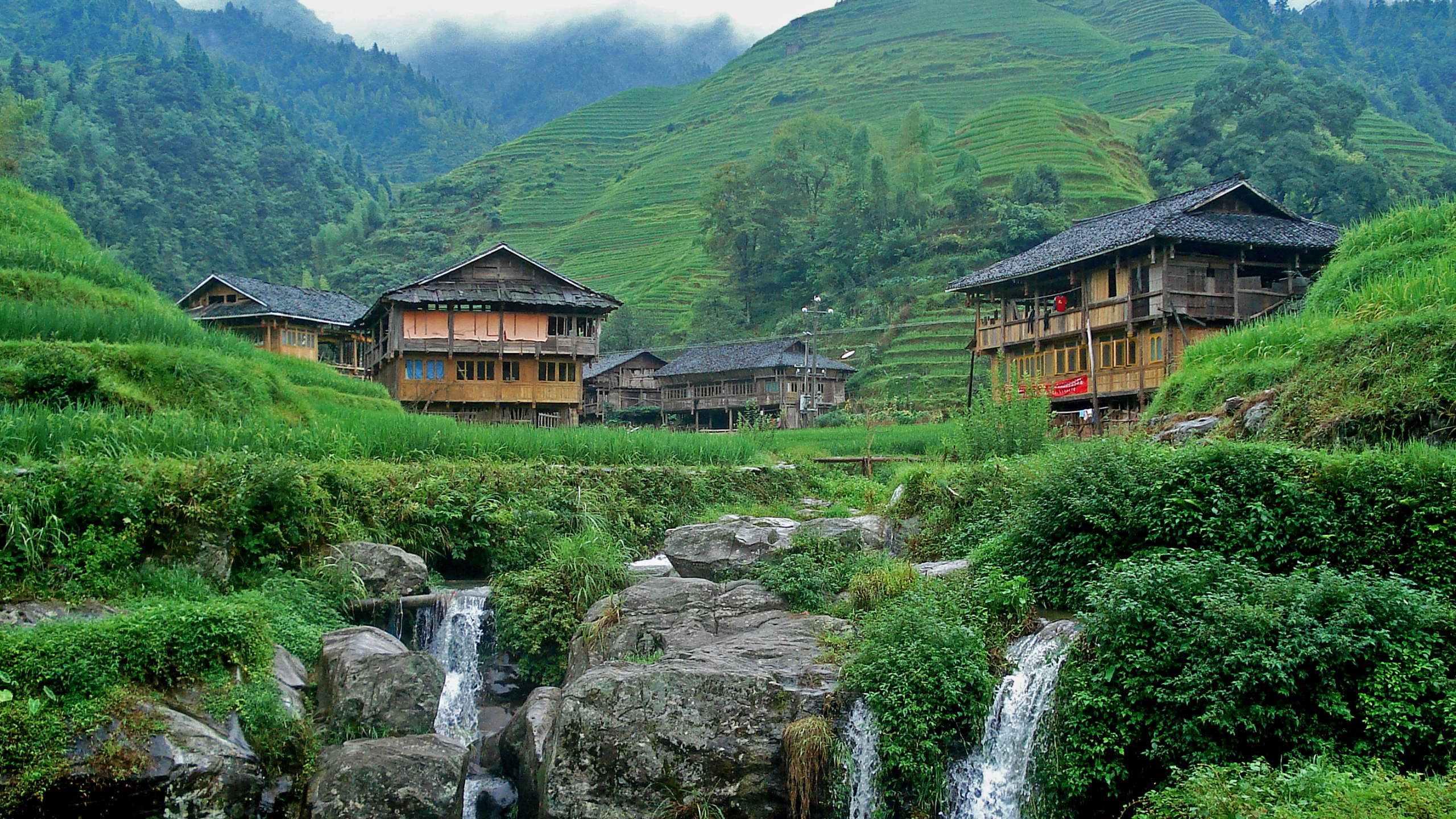 Brown Wooden House Near Water Falls During Daytime. Wallpaper in 2560x1440 Resolution