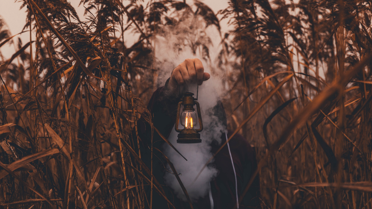 Person in Black Jacket Holding Brown Lantern. Wallpaper in 1280x720 Resolution