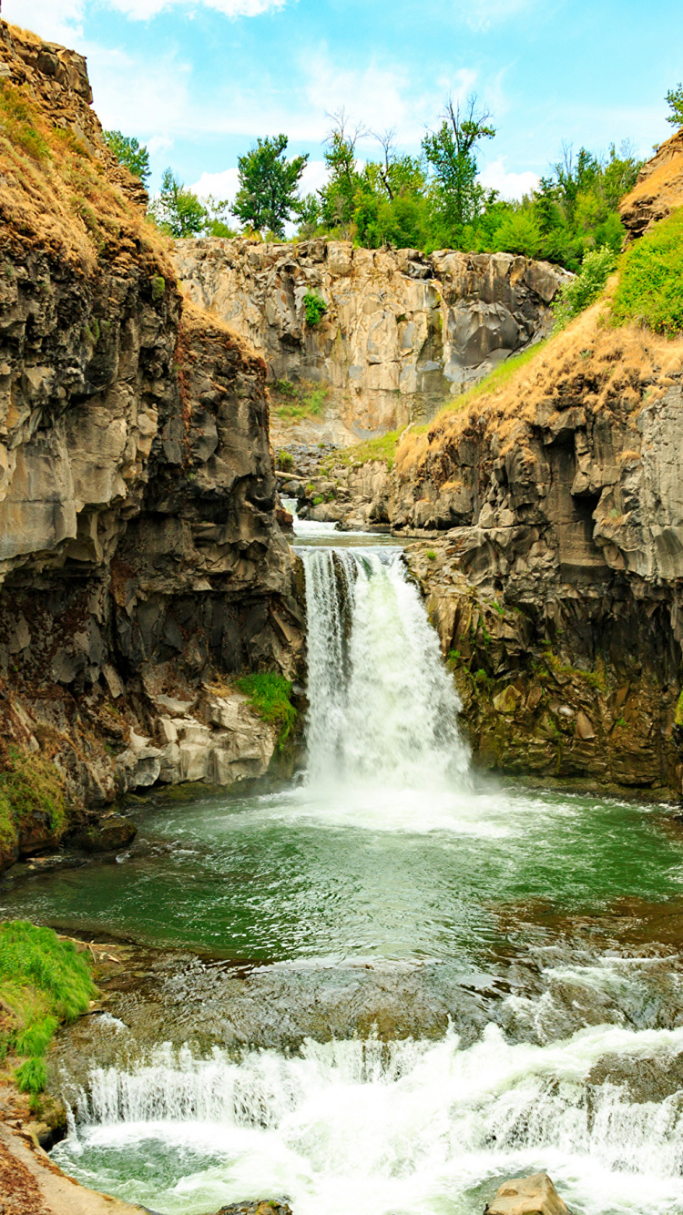 Wasserfälle Auf Braunem Felsigen Berg Unter Blauem Himmel Tagsüber. Wallpaper in 750x1334 Resolution