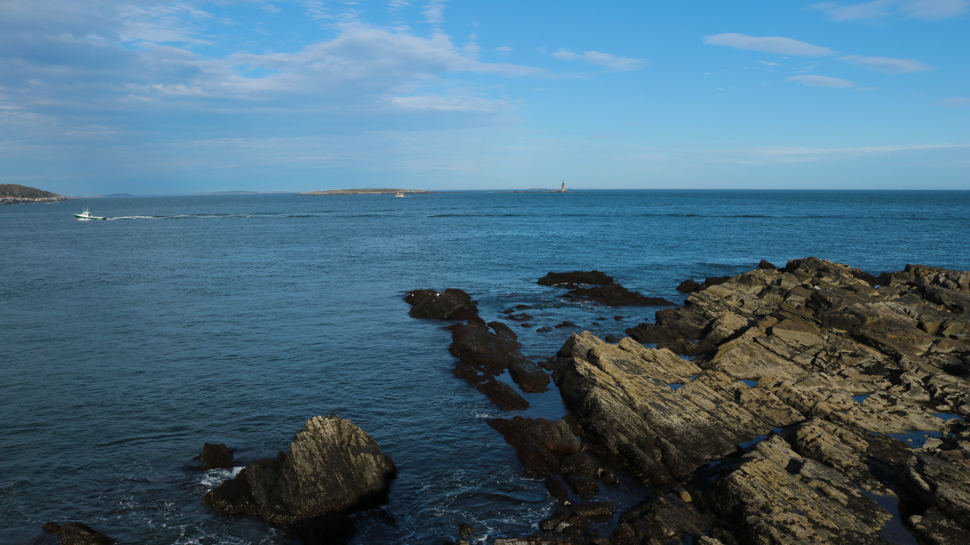 Roches Brunes Sur Mer Sous Ciel Bleu Pendant la Journée. Wallpaper in 1366x768 Resolution