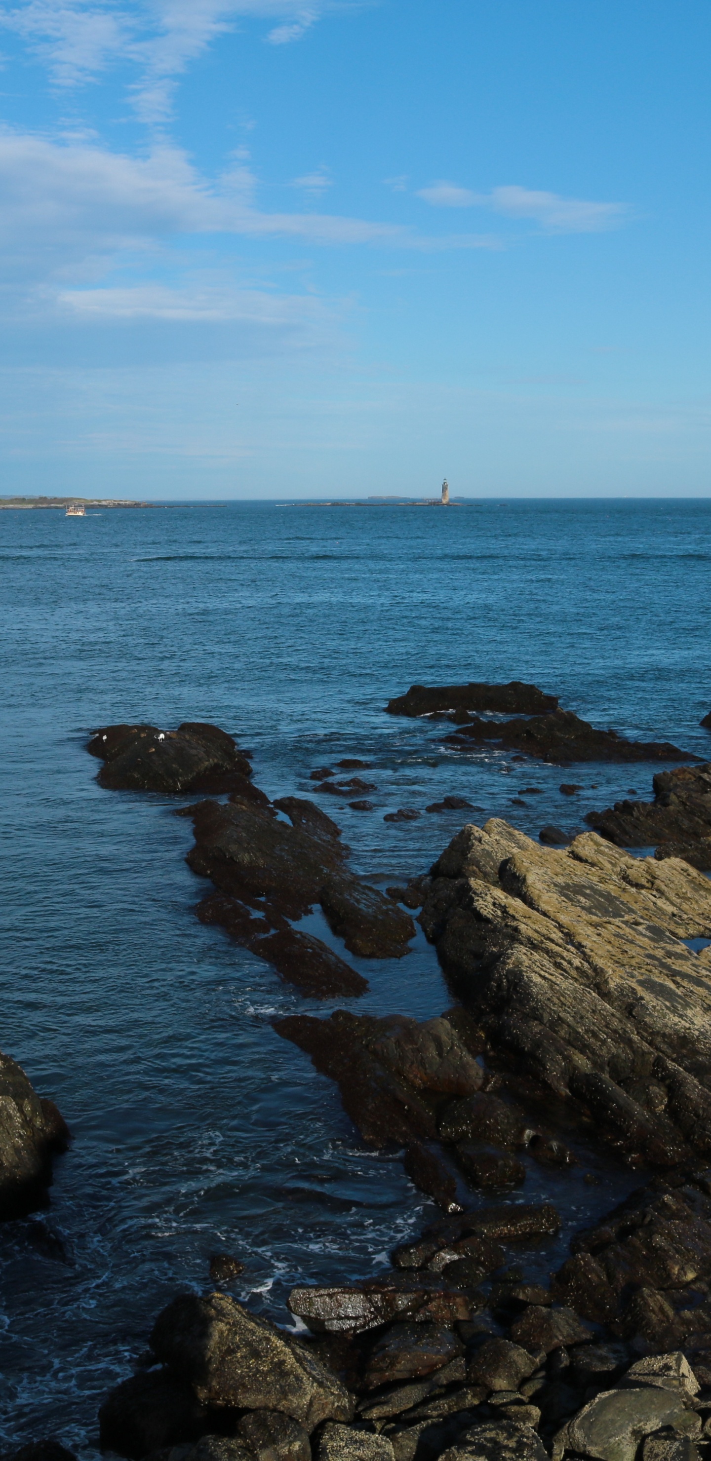 Brown Rocks on Sea Under Blue Sky During Daytime. Wallpaper in 1440x2960 Resolution