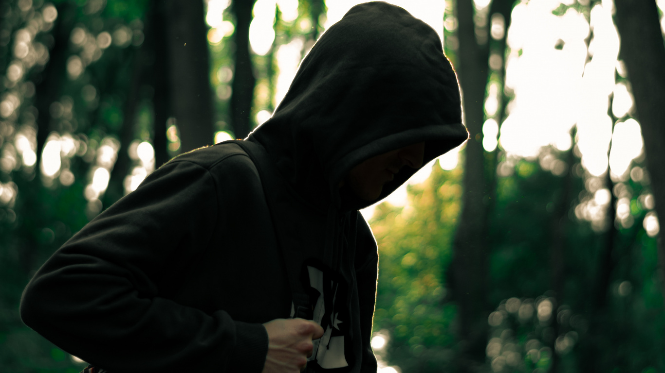 Man in Black Hoodie Debout Dans la Forêt Pendant la Journée. Wallpaper in 1366x768 Resolution