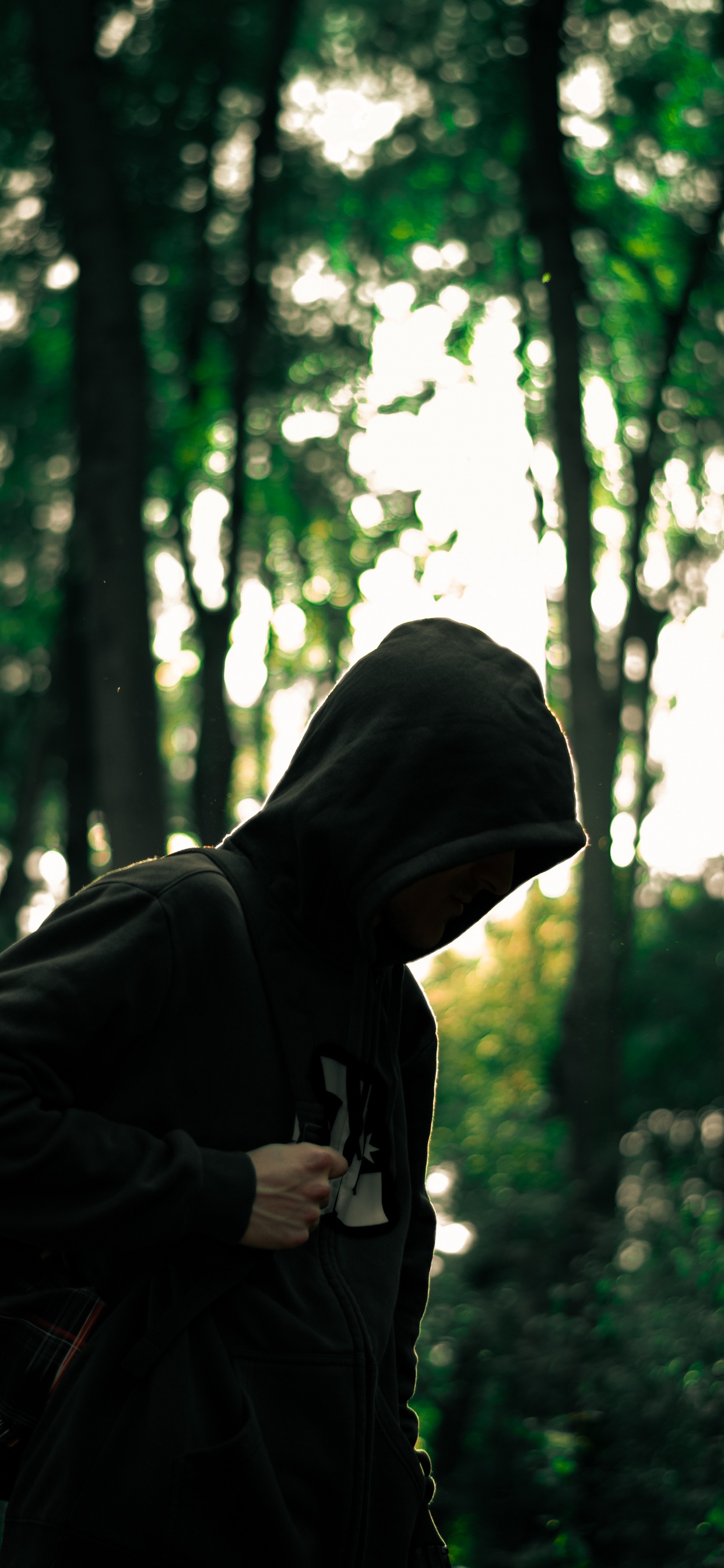 Man in Black Hoodie Standing in Forest During Daytime. Wallpaper in 1242x2688 Resolution
