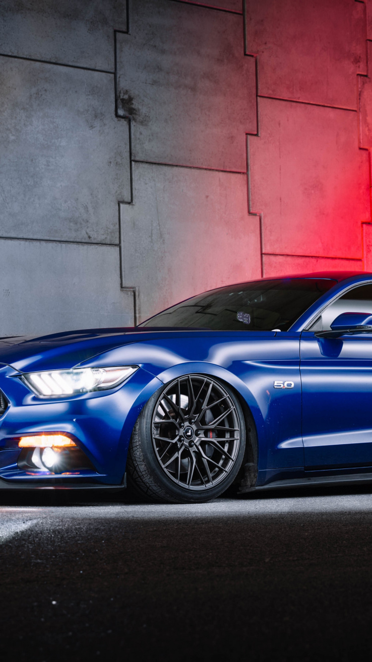 Blauer Porsche 911 Neben Roter Wand Geparkt. Wallpaper in 750x1334 Resolution