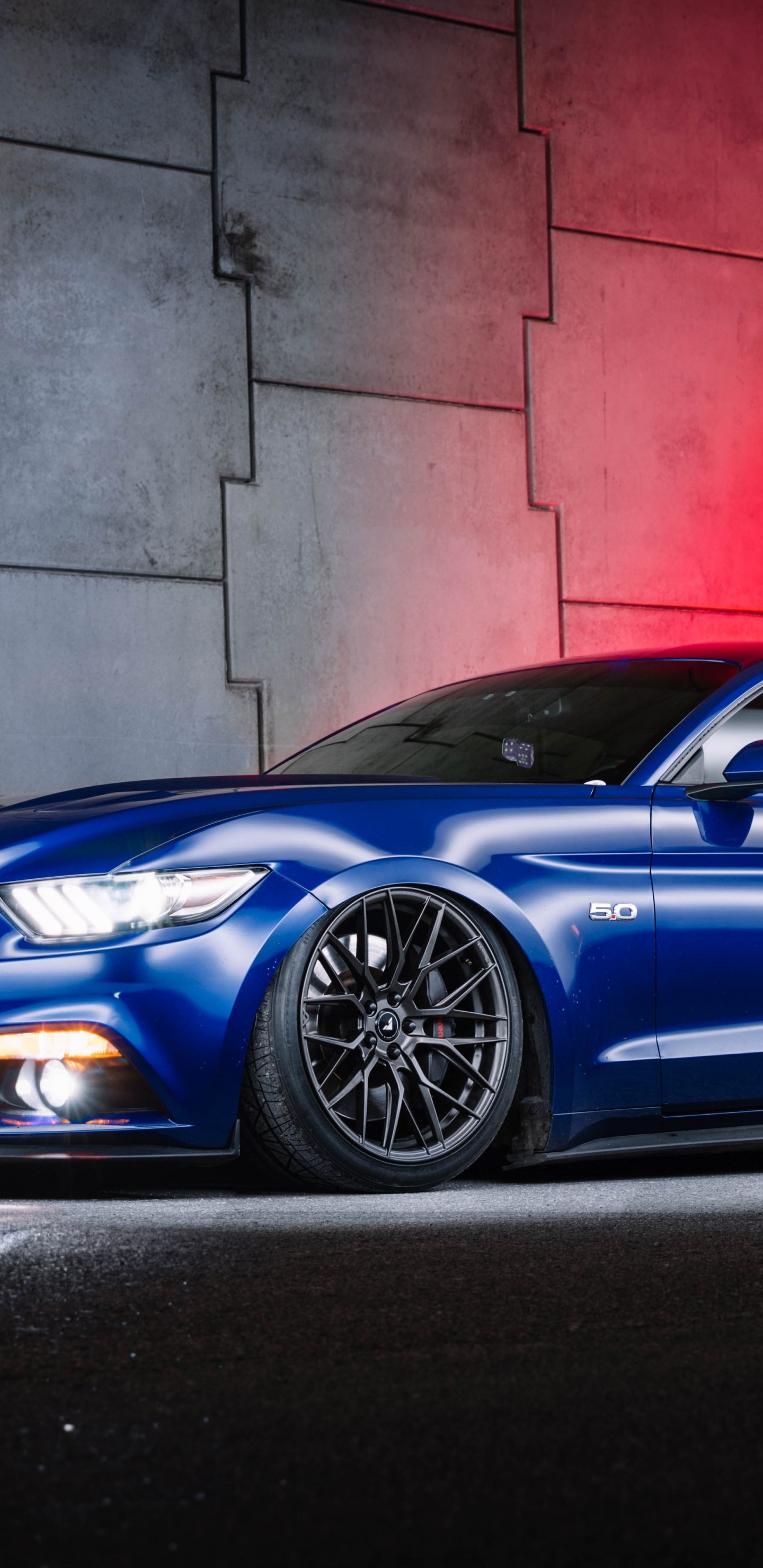 Blue Porsche 911 Parked Beside Red Wall. Wallpaper in 1440x2960 Resolution