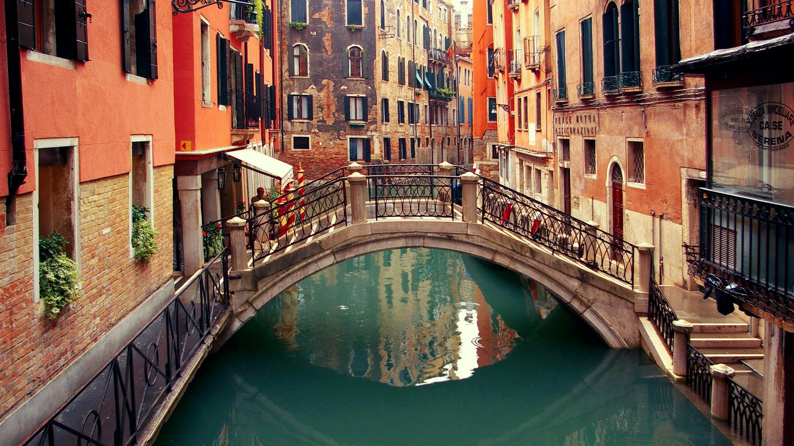 Bâtiment en Béton Brun et Blanc à Côté de la Rivière Pendant la Journée. Wallpaper in 2560x1440 Resolution