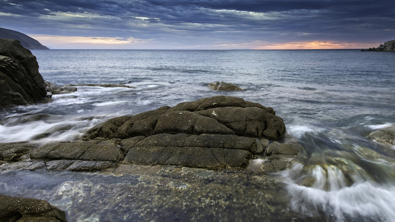 Brown Rock Formation on Sea Under Blue Sky During Daytime. Wallpaper in 1366x768 Resolution