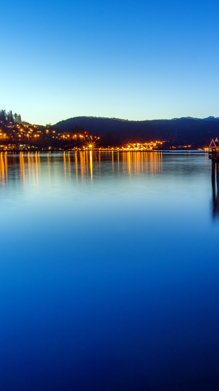 Cuerpo de Agua Cerca de la Ciudad Durante la Noche. Wallpaper in 750x1334 Resolution