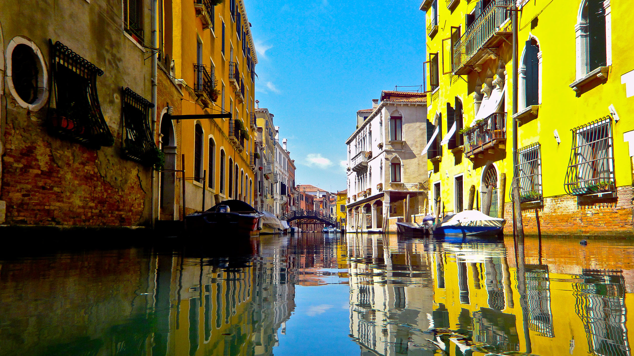 River Between Concrete Buildings Under Blue Sky During Daytime. Wallpaper in 2560x1440 Resolution