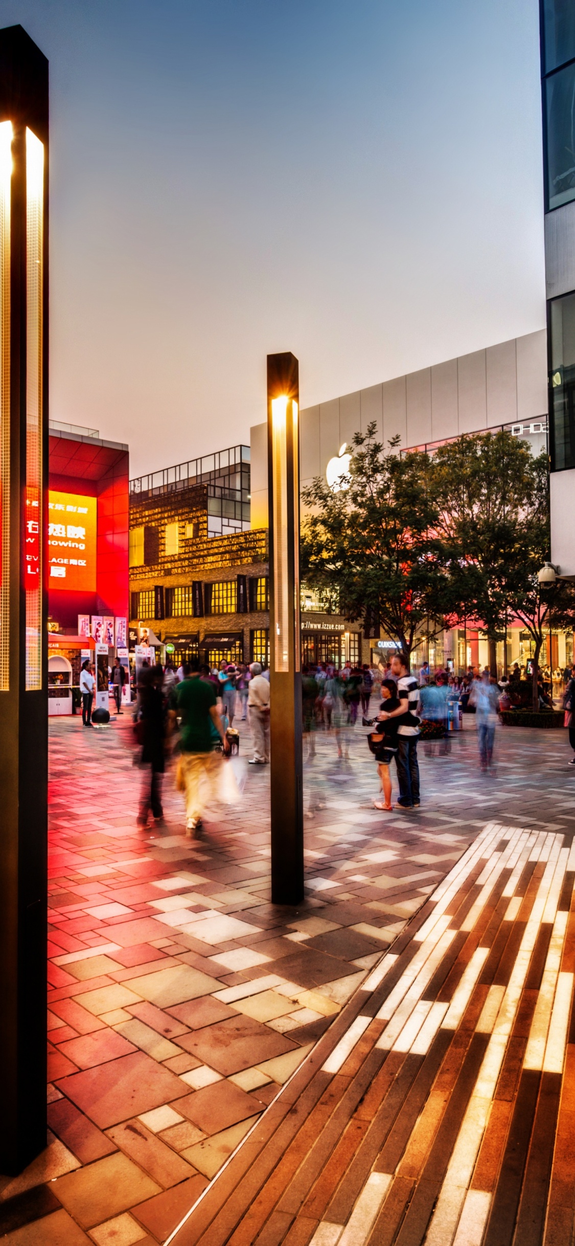Personnes Marchant Sur le Trottoir Près du Bâtiment Pendant la Nuit. Wallpaper in 1125x2436 Resolution